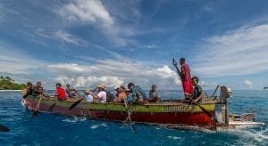 Pupua New Guinea fishing men at sea in a traditional boat