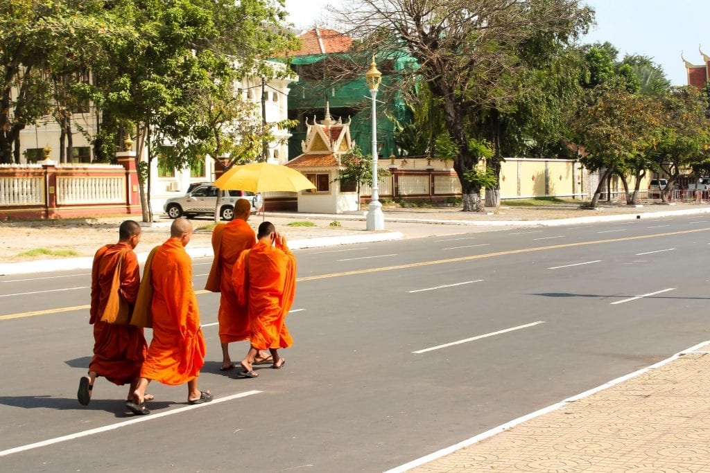 Buddhist monks walking down the road in their orange robes