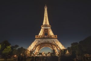 The Eiffel Tower in Paris at night, lit by thousands of light bulbs
