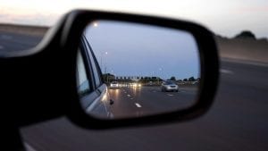 the wing mirror of a car, showing traffic behind on the motorway