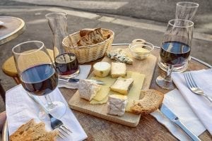 a cheese board with some red wine