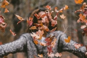 woman throwing leaves in the air