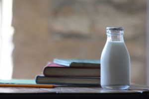 a small bottle of milk with school books