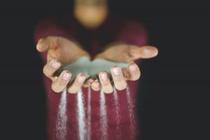 grains of sand falling through fingers