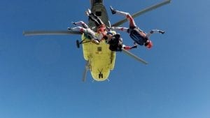 people skydiving out of a helicopter 