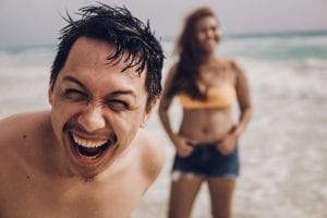 young couple laughing together on the beach