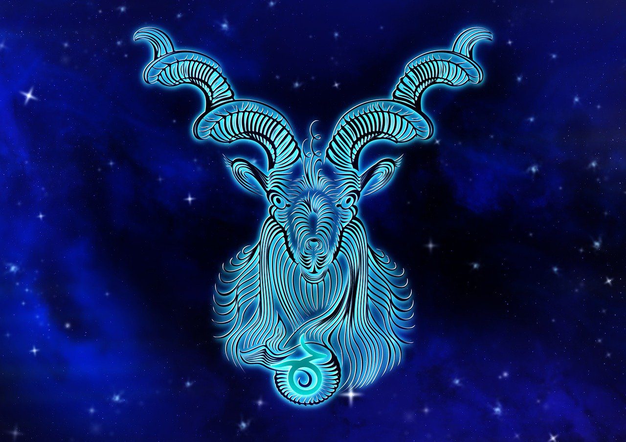  A blue Capricorn zodiac sign with long horns and a fish-like tail against a background of stars.