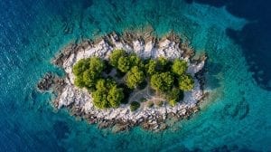A drone shot of a tiny island in The Adriatic Sea