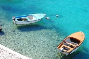 2 small boats floating in the crystal clear Adriatic Sea