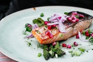 a salmon fillet with salad items