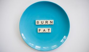 plate with scrabble letters - burn fat - on it