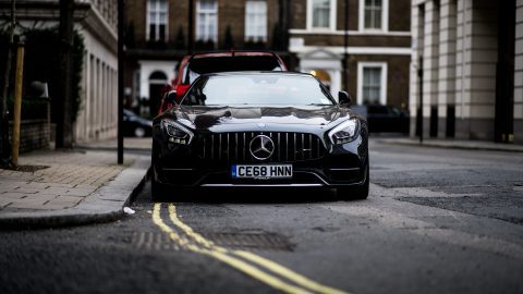 a black Mercedes Benz GT parked of double yellow lines in London