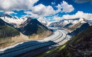 a glacier pushing and cutting its way down the mountains