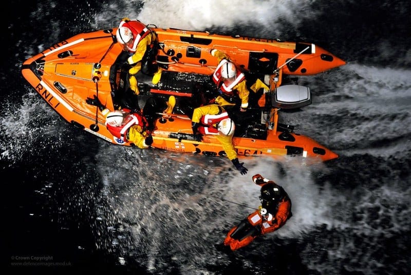 A small orange RNLI rib on rescue exercises