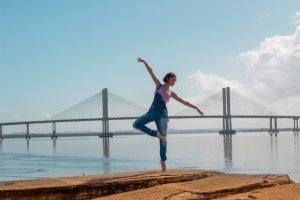 young woman striking a yoga pose outside