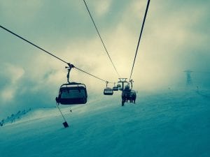 mountain gondolas carrying snowboarders and skiers up a mountain