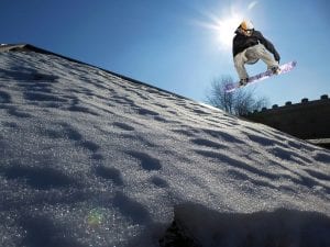 a snowboarder jumping off a ramp