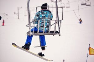 a Snowboarder using a chair lift back up the mountain