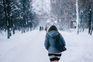 Young woman walking in the cold snow