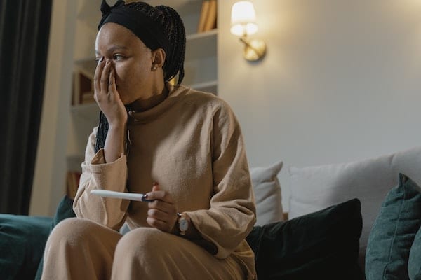 Anxious woman holding pregnancy test