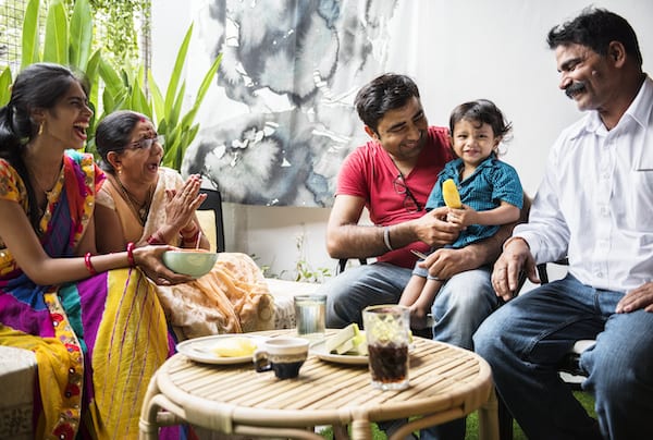 Indian family laughing and passing food at the table