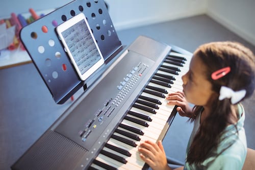 Elementary girl practicing digital piano at school