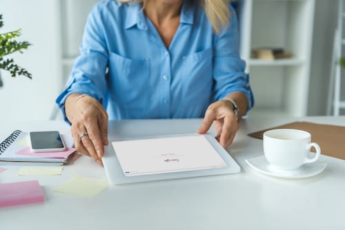 Businesswoman using digital tablet with Google website