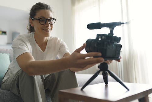 Youtuber and vlogger sitting on the couch recording a video