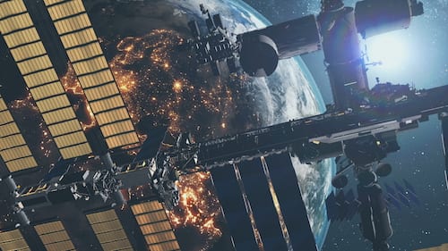 International Space Station with solar charging panels flies in outer space against starlight.