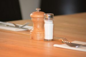 A typical looking salt cellar with pepper on a table ready for dinner