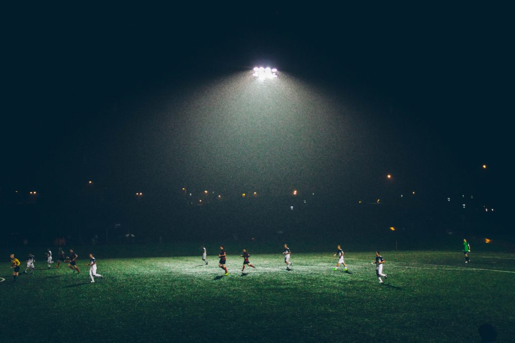 Playing football on a pitch at night with lighting