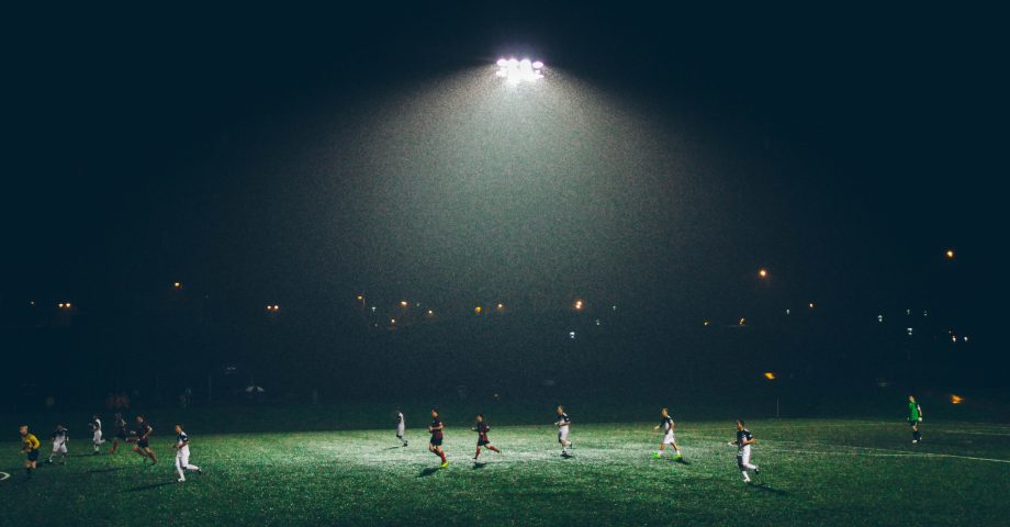 Playing football on a pitch at night with lighting